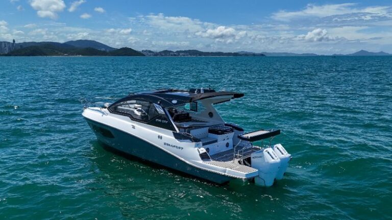 Premium boats docked at a sunny coats with clear blue skies and calm water