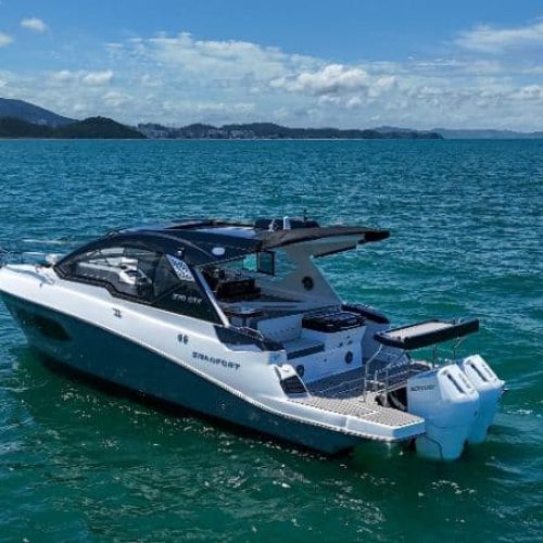Premium boats docked at a sunny coats with clear blue skies and calm water